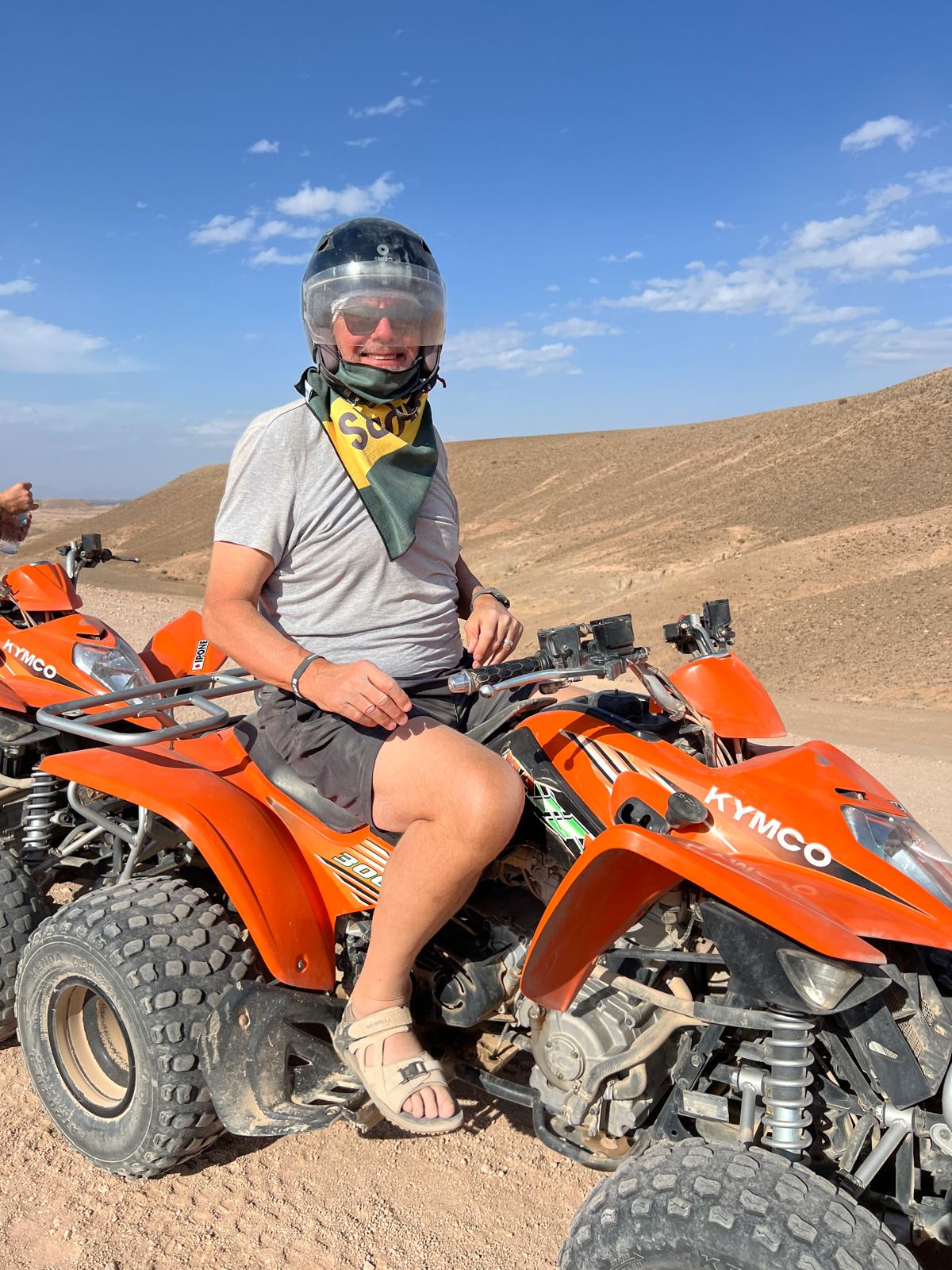 A quad-bike rider posing in the desert