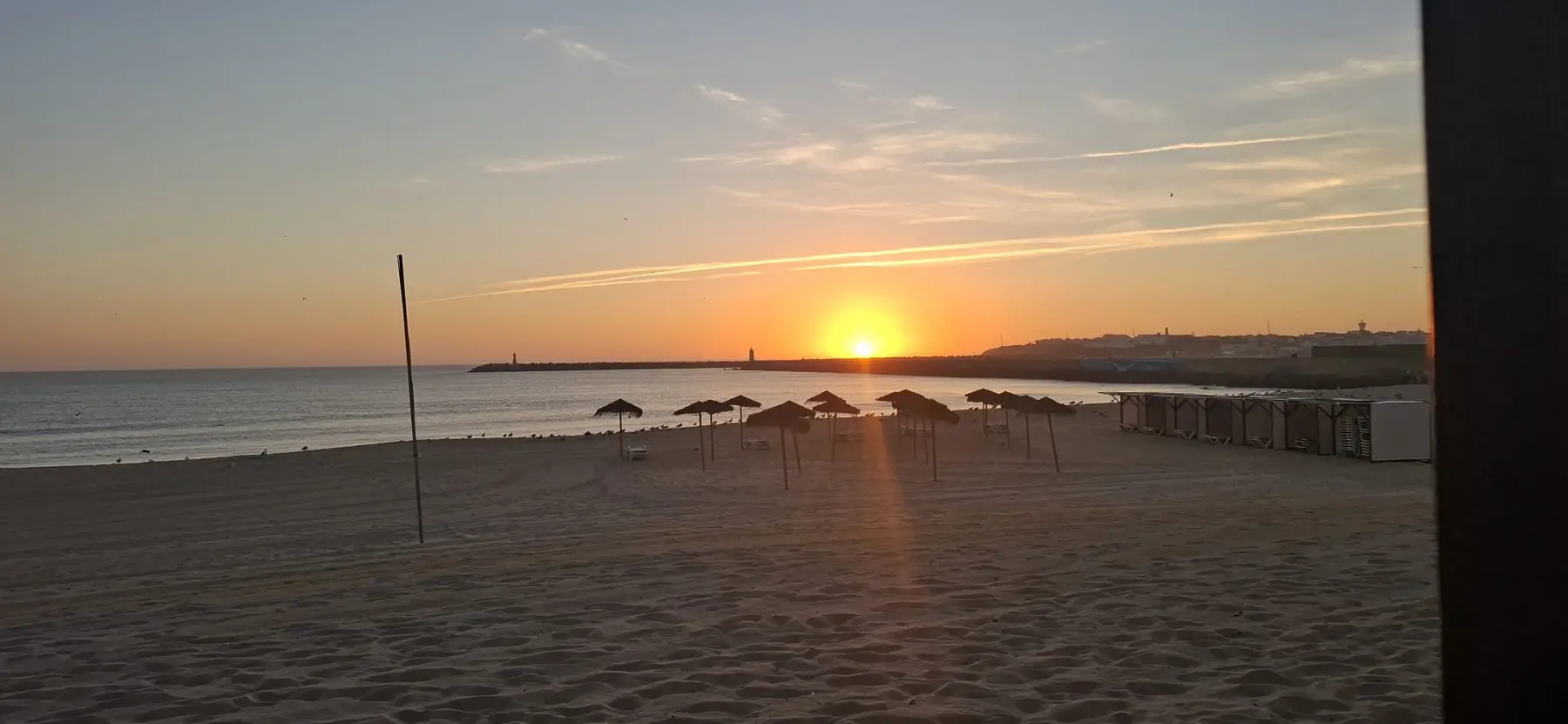 Sunset over the beach and harbour at Peniche